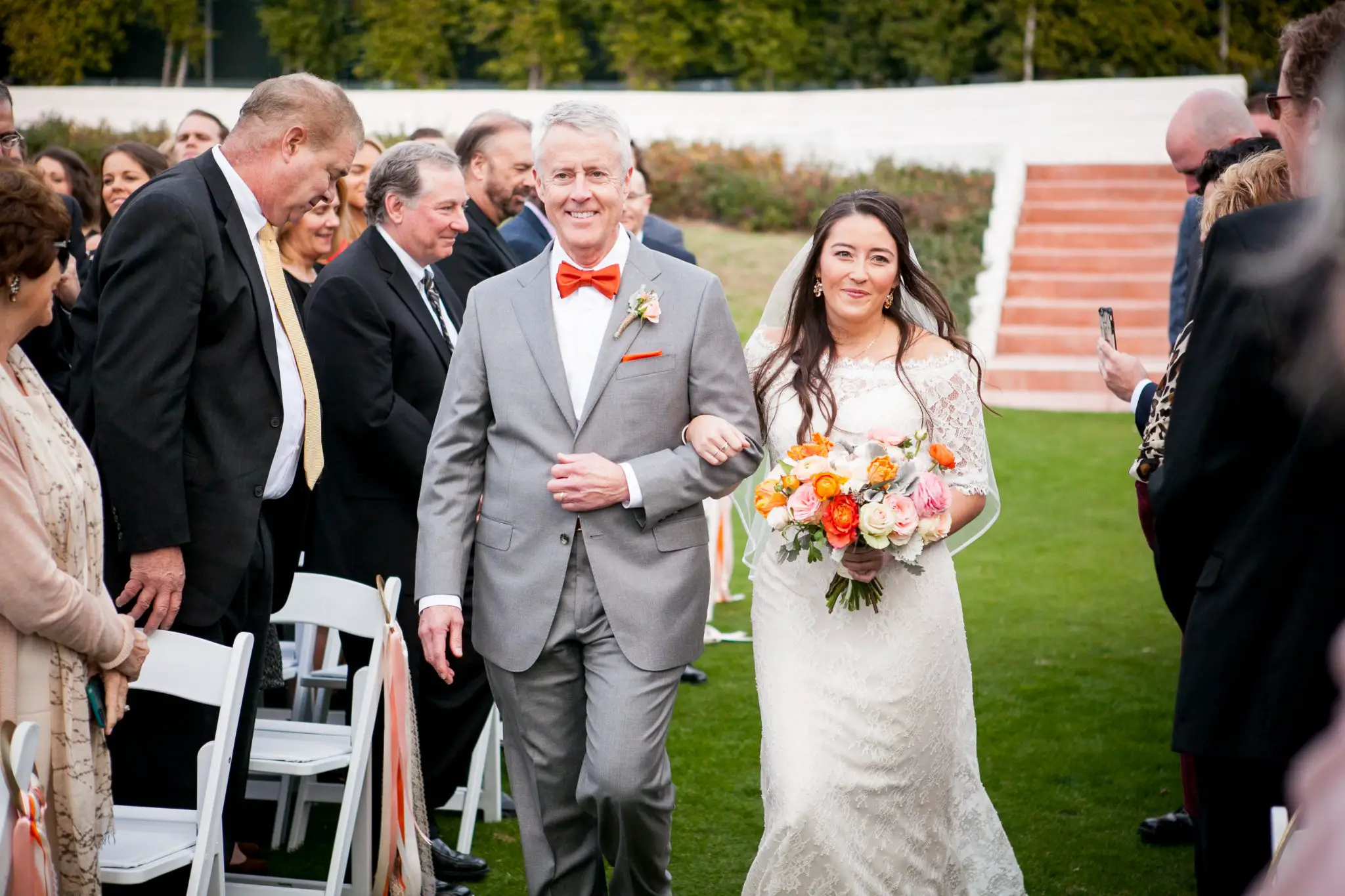 bride walks down the wedding ceremony aisle with her father