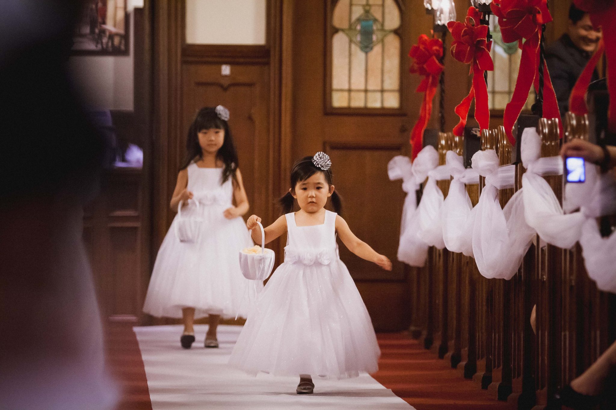 Flower girl running down the aisle during the wedding ceremony in San Diego