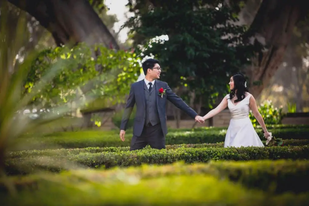 Couple walking through the greenery at Balboa Park for their wedding photos