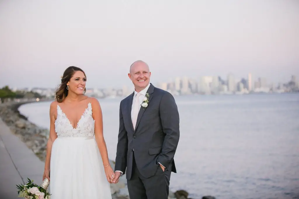 Wedding couple holding hands with downtown San Diego in the distance