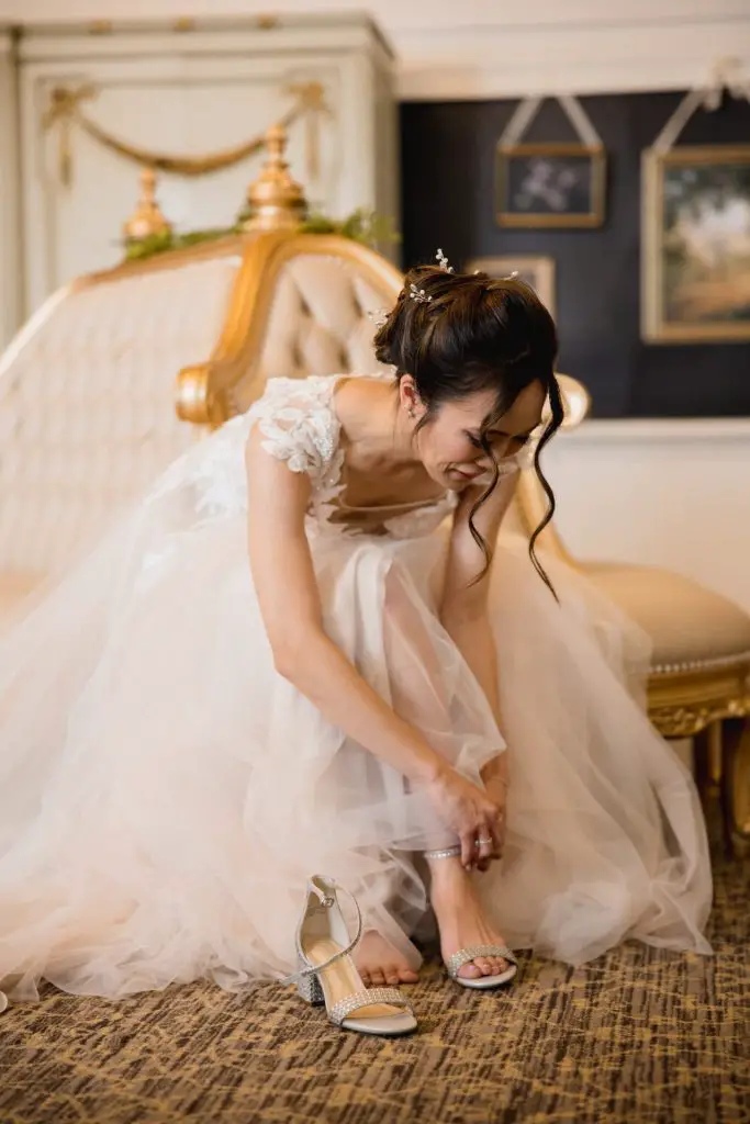 Bride putting on her open toed heels on her wedding day